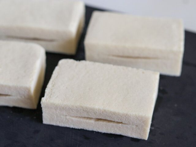 高野豆腐の水気をしぼり、半分に切ってから、袋状になるよう切り込みを入れる。
