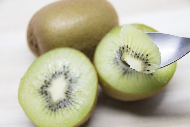 カットされたグリーンキウイとそれを掬うスプーン