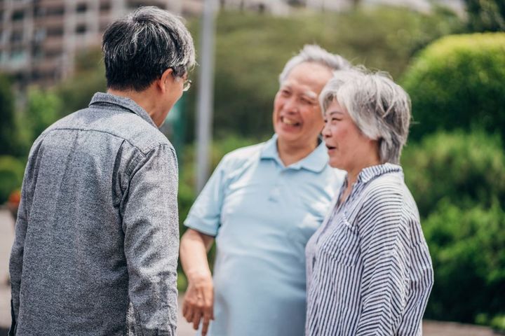 成熟した息子と公園に立っているシニアカップル