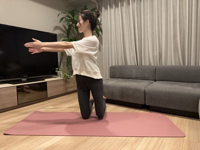 膝立ちツイスト：息を吐きながら、上半身を右にツイストし、息を吸いながら元の位置に戻る。このとき、左足を少し浮かせる