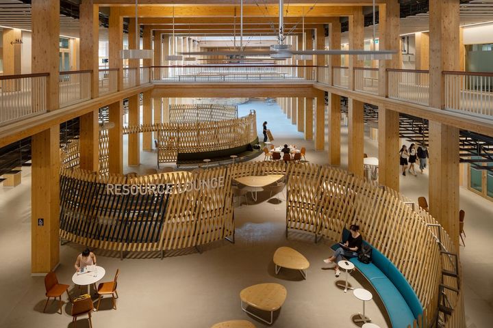 並列する2棟を結ぶ中央部分は3層吹き抜けで、エントランスや共有フリースペースに。Photo_ Kai Nakamura