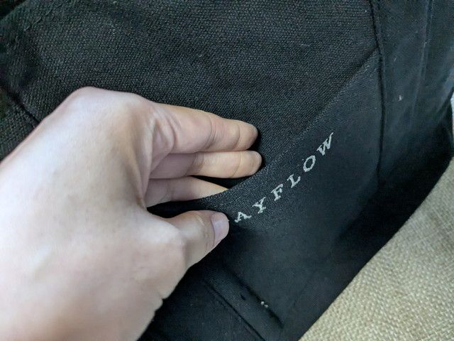 フロントポケットに指を入れている様子。スマホやパスなどを差し込みやすい外ポケット