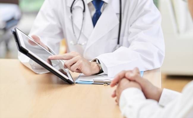 医師に診察をしてもらう男性のイメージ