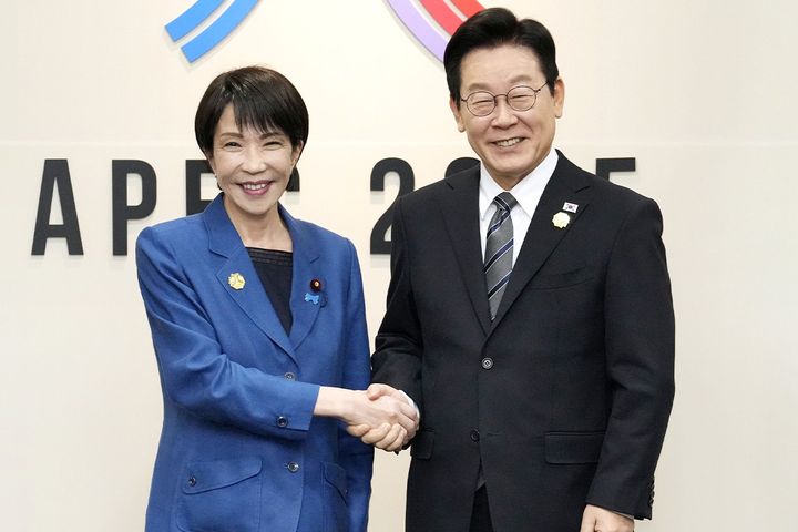 日韓首脳会談を前に、韓国の李在明大統領（右）と握手する高市早苗首相（2025年10月30日、時事）