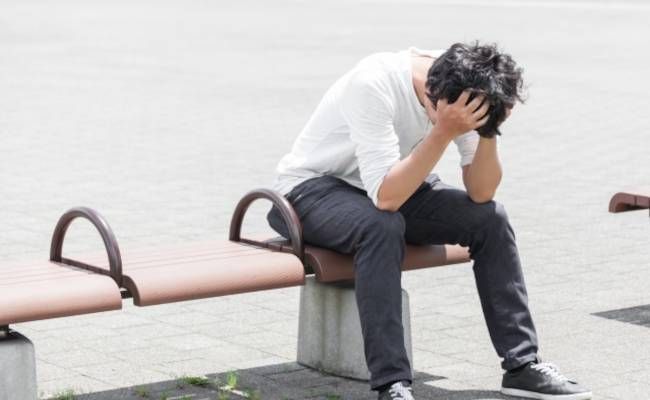 頭を抱える男性のイメージ