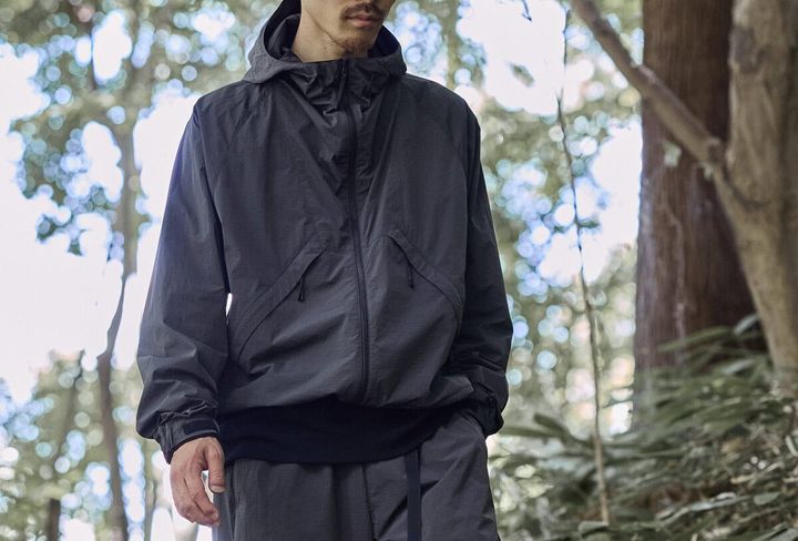Goldwinのインラインモデル「Hooded Jacket」をベースに、従来の染色方法に比べて水の使用量や化学薬品の使用量を大幅に削減するドープダイを採用したリップストップナイロン素材を採用。都会にも自然にも溶け込むカーボングレーが、アーバンアウトドアなムードをより一層高めてくれる。