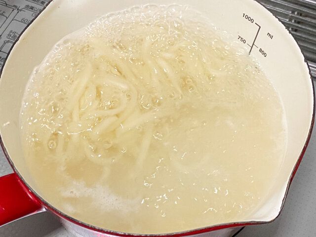 鍋に湯を沸かし、冷凍うどんをゆでる。