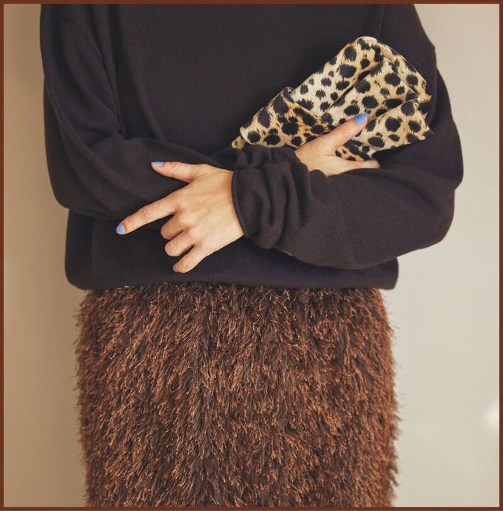 プレーンなニットにフリンジスカートを添えて艶やかに。小物もブラウン系でまとめてシックに。 ニット4万9500円（ハウス オブ ロータス 二子玉川店） スカート2万6400円（ザ ポーズ／ウィムガゼット ルミネ新宿店） バッグ2万3100円（ルレ・アッシュ／ピモンテ） 