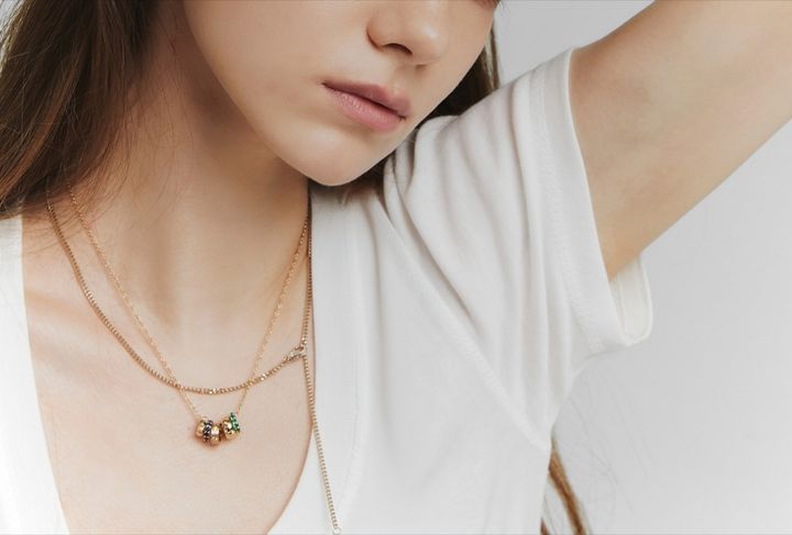 白いカットソーにネックレスを組み合わせたコーデの女性