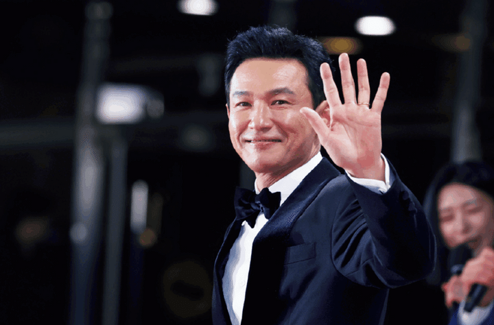 1970年生まれ。90年に『将軍の息子』で俳優デビュー後、映画『新しき世界』や『国際市場で逢いましょう『』ベテラン』など数々の話題作に出演。 『ハッシュ～沈黙注意報～』や『ナルコの神』などのドラマや舞台『マクベス』などでも活躍。 不倫する弁護士や破天荒な熱血刑事、悪徳市長など幅広い役柄をこなす。 『ソウルの春』では特殊メイクで劇的な変身を遂げ、新たな独裁者としてクーデターを決行するチョン・ドゥグァン保安司令官を怪演して話題に。 写真：YONHAP NEWS/アフロ