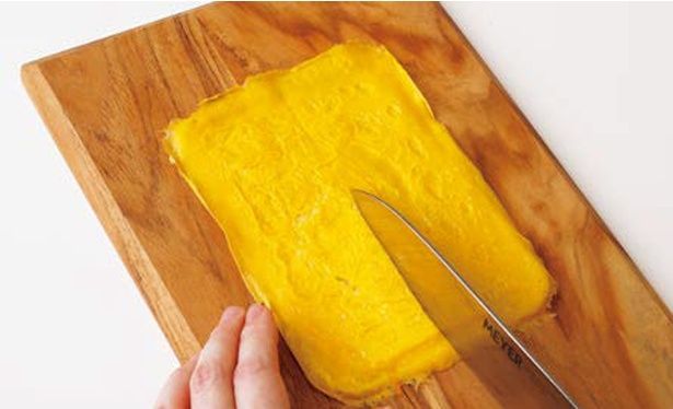 焼き上がった卵をまな板に取り出し、縦半分にカット (C)つやこママ／KADOKAWA