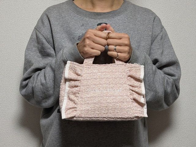 ジルスチュアートツイードフリルバッグ手に持ったところ