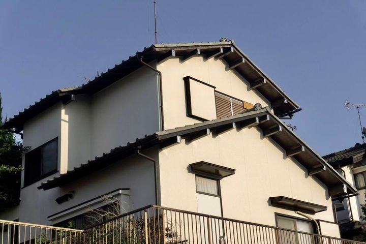 雨戸の閉まった2階建ての家
