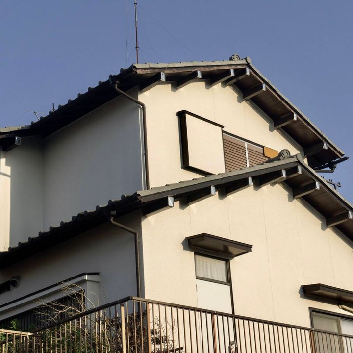 雨戸の閉まった2階建ての家