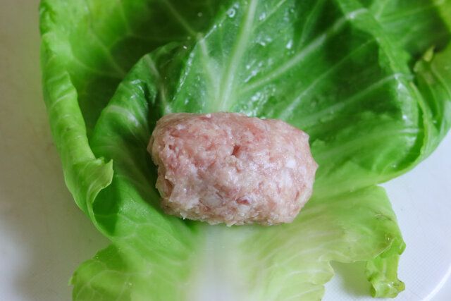 中央より手前側に肉だねを置き、手前のキャベツを巻き付けたら、左右の葉を折り込み、くるくると巻く。