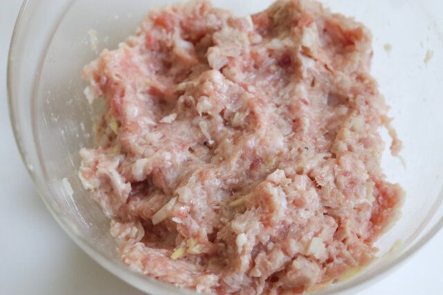 ボウルに豚ひき肉、たまねぎ、にんにく、牛乳、パン粉、塩、こしょうを入れ、粘りが出るまでよく混ぜ合わせる。