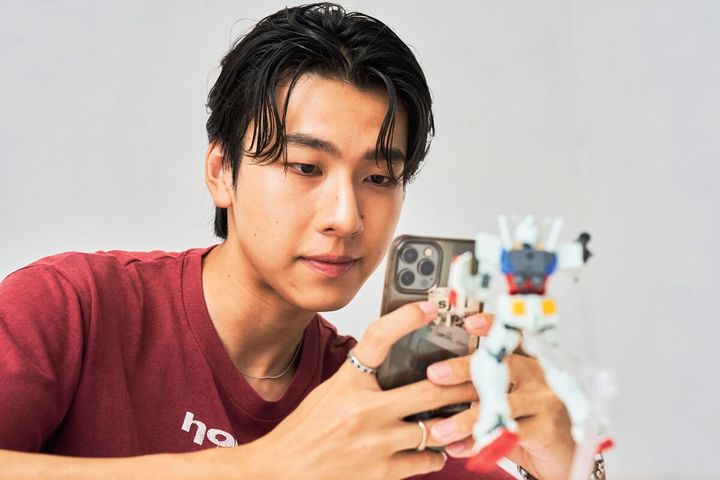 完成したガンプラを撮影するsmartモデル一ノ本くん