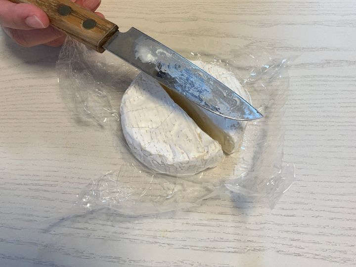 カマンベールチーズを包丁で切る