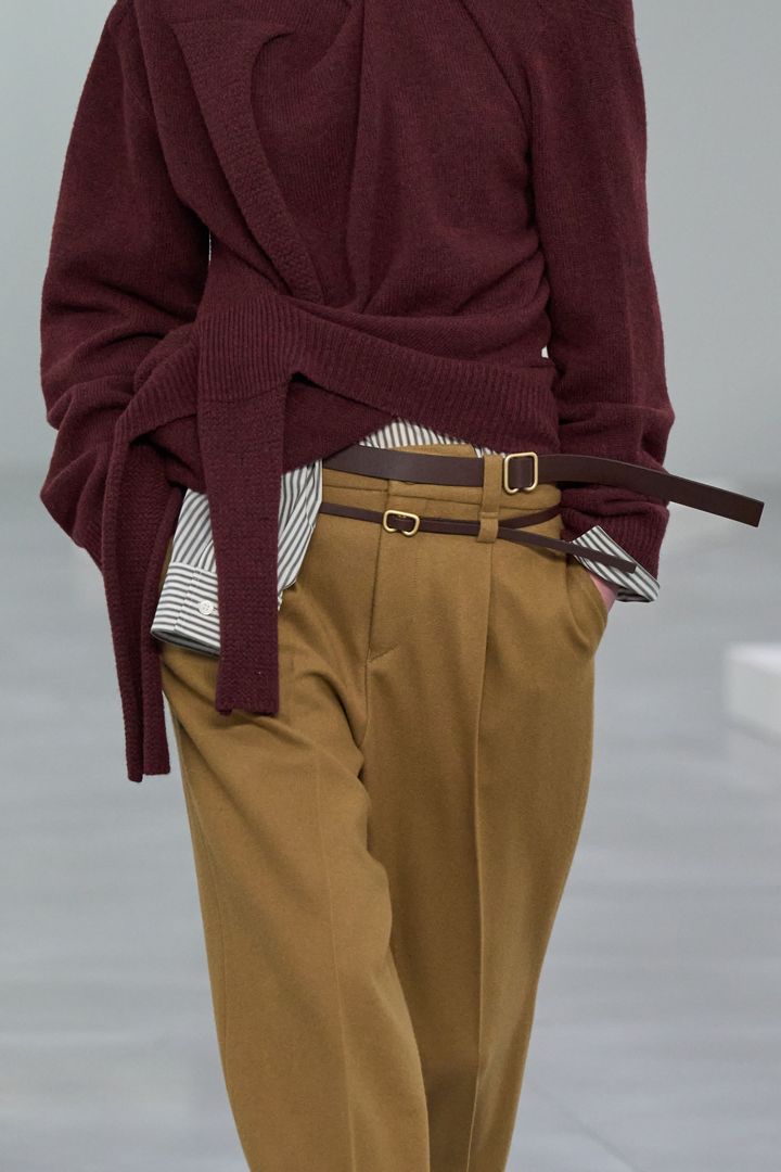 イッセイ ミヤケ 2025-26年秋冬コレクション。ベルトループが2つ付いたパンツは、大小異なるベルトのコントラストが楽しめる。
