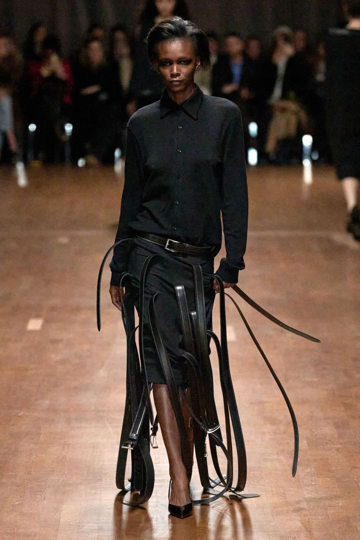 ホダコヴァ 2025-26年秋冬コレクション。タイトスカートから無数のベルトが飛び出した、まるでフリンジのような遊び心が楽しい。