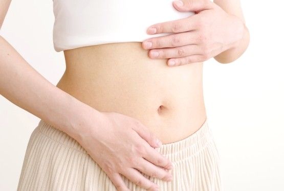 お腹に手を当てる女性