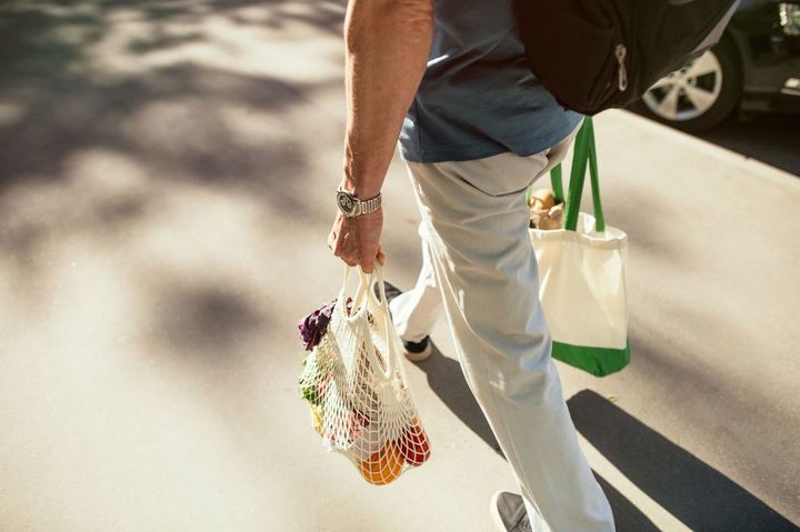 エコバッグに購入した食料品などを入れて持って歩いている男性