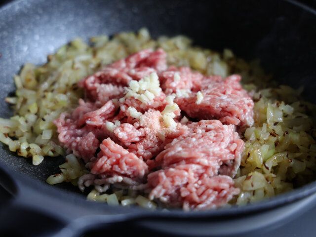 玉ねぎを入れて色づくまで炒めたら、隙間を作り、にんにくと合いびき肉を入れて、下味に塩も入れ炒める。