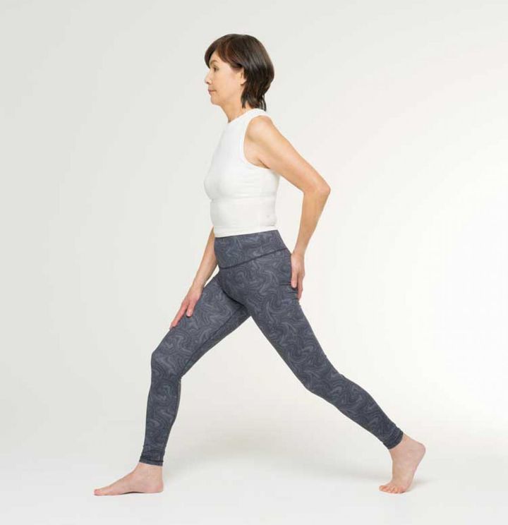 【２】右足を大きく前に出します。右手は右足の太ももにおき、左手はお尻の左側にあてます。