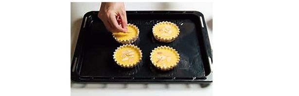 溶かしたバターを加えて混ぜたら、カップに流し入れ、アーモンドスライスをのせる （C）HIRO SWEETS／KADOKAWA