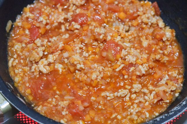 肉の色が変わったら、カットトマト缶、ケチャップ、砂糖、中濃ソース、顆粒コンソメ、塩を加えて、煮詰めながら混ぜ合わせる。