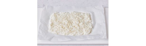 オーブン用ペーパーを20cm長さに切ってご飯をのせ、水でぬらしたスプーンで薄くのばす （C）韓国人オッパ セミ／KADOKAWA