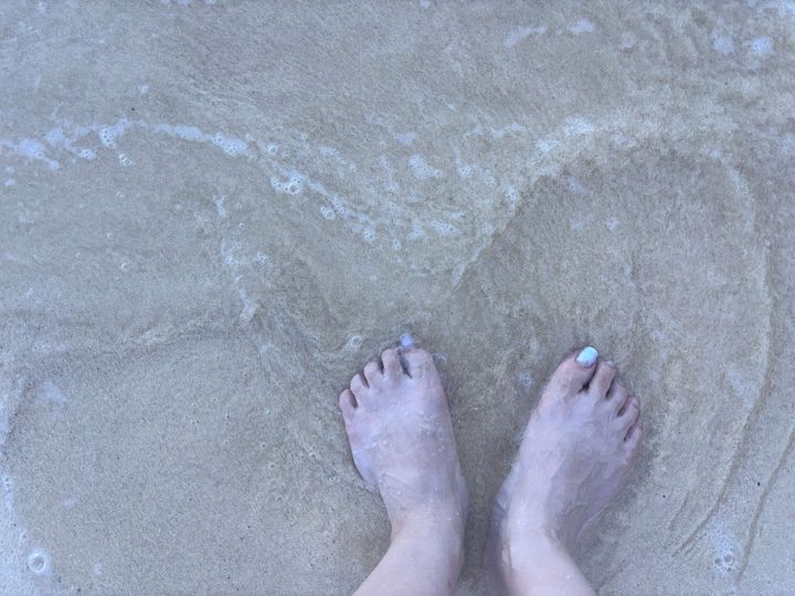 裸足で大地の上に立つだけで体内の静電気を排出するといわれるアーシング。ここでは波に足を浸すことで浄化作用も得られる。