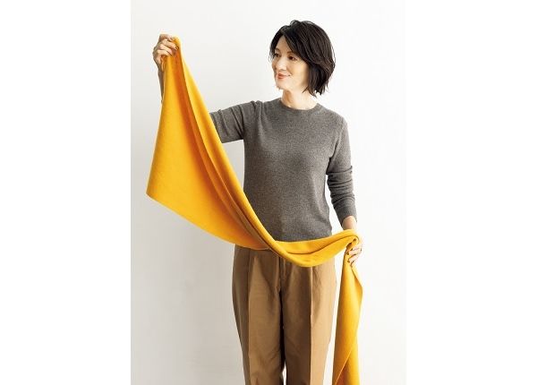 ストールの片方の端を持ってから、中心あたりを軽く持ち、首にかける