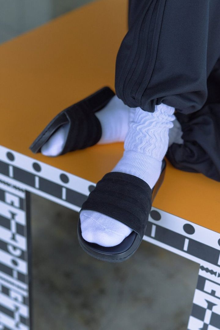 さらに、スライドサンダルである「ADILETTE MII e 」は、こだわり抜かれた Made In Italy の特別仕様。「STANSMITH」と同様、撥水性のあるイタリアンレザーの牛スエードをバンドに採用し、ミニマルかつ洗練された立体的なスリーストライプスを表現した。