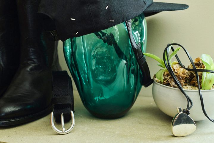 バッグ（HERITAGE LEATHER）、ブーツ（LUCCHESE）、キャップ（MAISON MARGIELA）、ネックレス（VINTAGE HERMES）