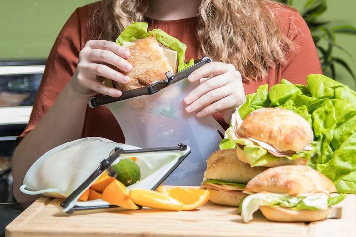 サンドイッチを袋に入れる女性