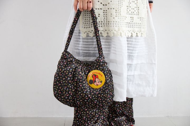 ミニーの缶バッジをつけた、フィグ ロンドンの小花柄ベロア素材の中綿バッグ