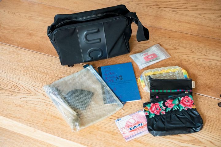 海外旅行用の手持ちバッグ。ノート、現地通貨を小銭と紙幣に分けて入れるポーチ、薬のミニ袋、使い捨てカイロ。