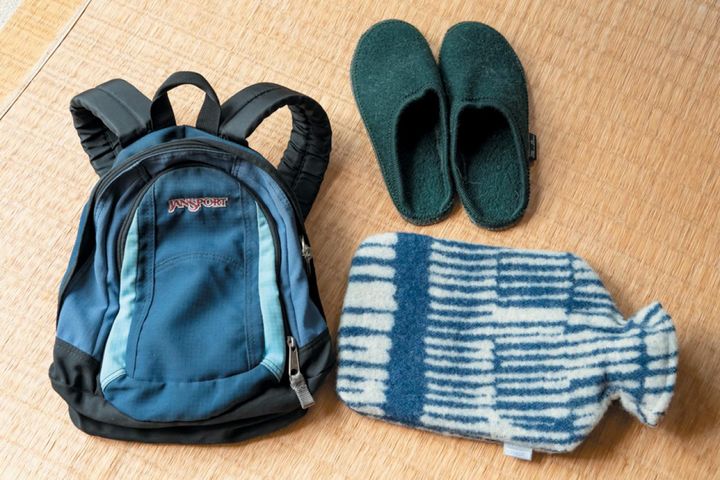 寒い国に旅するときの荷物。右上の室内履きはとても暖かい。下の湯たんぽは北欧で購入。寒さに弱い阿部さんの必需品。リュックはミニサイズ。どれも現地調達。