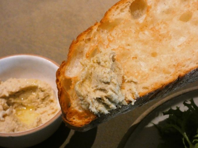 ブルーボトルコーヒー 福岡天神カフェ パンストックのバケットにフムスをつけた様子