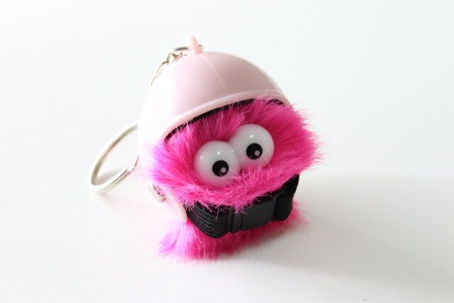 ダイソーのエコファーキーホルダー ギョロ目モンスター カラフルにヘルメットのキーホルダーを被せた様子