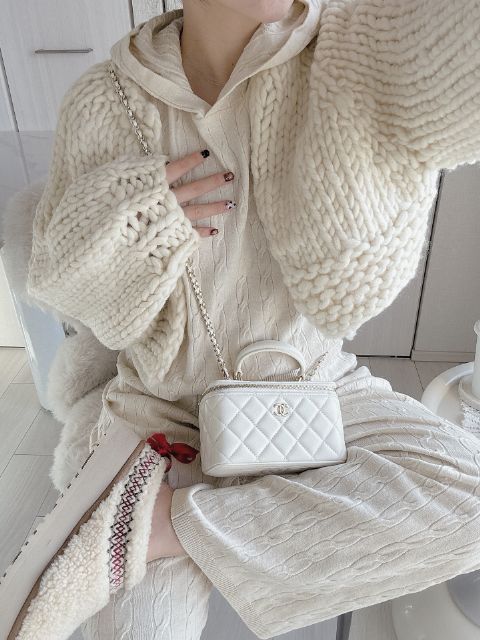 白のウォッシャブルニットケーブルパーカーとウォッシャブルニットケーブルパンツとニットカーディガンを着たコーデ