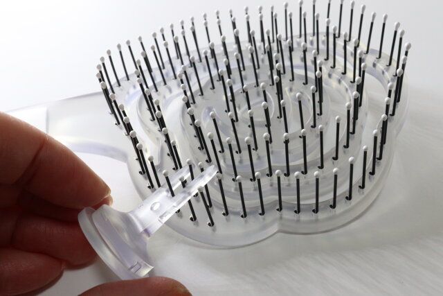 ダイソーの立てられる乾きやすいブローブラシ クリア・花型は付属のミニクリーナーで髪の毛を取り除ける