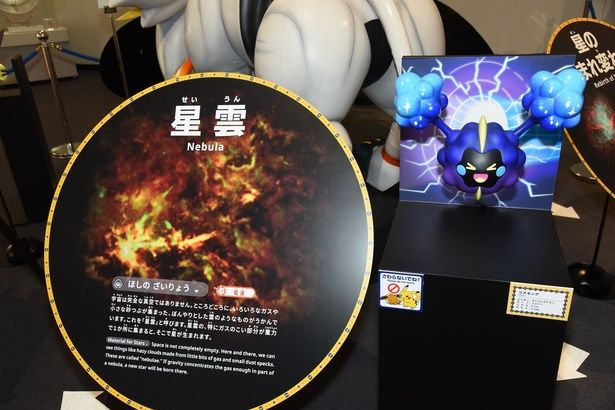 星雲の紹介パネルと、せいうんポケモンのコスモッグ (C) 2025 Pokemon. (C) Nintendo/Creatures Inc./GAME FREAK inc. ポケットモンスター・ポケモン・Pokemonは任天堂・クリーチャーズ・ゲームフリークの登録商標です。