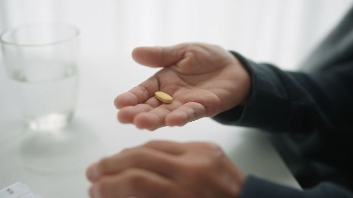 錠剤を持つ老人の手