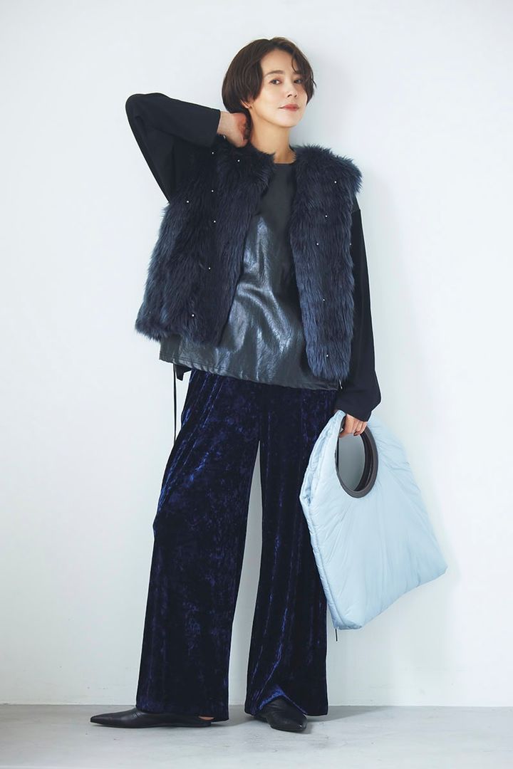 ネイビーのビジュー付きフェイクファーのベストとベロアパンツ、黒のフェイクレザー切り替えトップスでクールに。ベスト7万400円（ミュベール） カットソー2万4200円（ミュラー オブ ヨシオクボ） パンツ2万3100円（リエス） バッグ4万8400円（ペレック） 靴4万9500円（フミエタナカ／ドール）