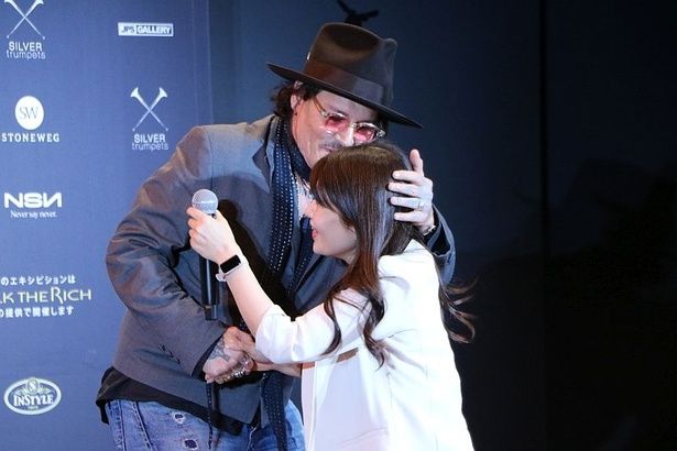 司会者の健闘を称えてハグするデップ