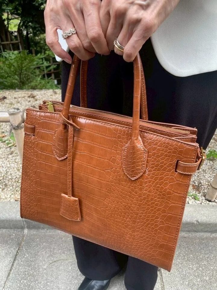 「洋服が白黒なので、コントラストを和らげる意味でブラウンのバッグを選びました」