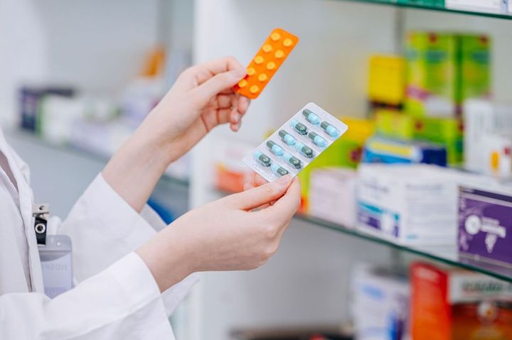 薬局で薬を見比べる薬剤師