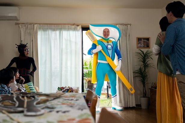 歯磨き粉のCMに巨大な歯ブラシを持つヒーローとして登場するフィリップ [c]2025 Searchlight Pictures. All Rights Reserved.